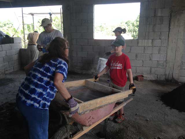 The image shows of participants in a community service event in the Dominican Republic.