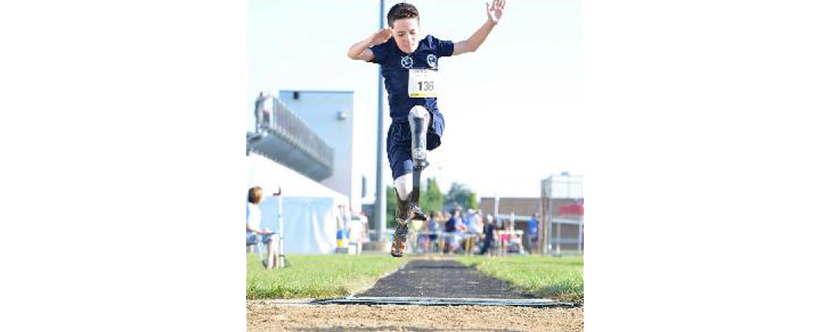 Image of young man with prosthetic leg in a long jump event for a track competition.