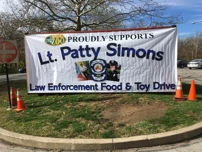 Lt Patty Simmons Food Drive New. Image of banner outside of zoo showing support for a local toy & food drive.
