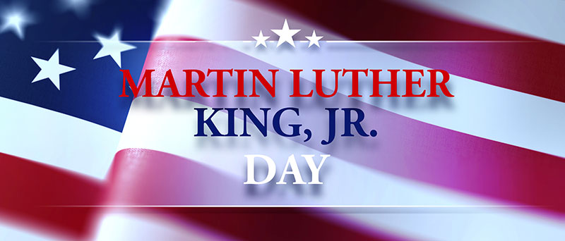 Banner image for Martin Luther king, jr.Day. Background is a waving American flag. Text is spelled out in red white and blue. Text is placed inside a star banner design.